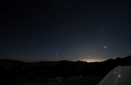 Širokoúhlý záběr foťákem položeným na střechu auta – kometa vlevo, vpravo Venuše v Hyadách, nad ní Plejády