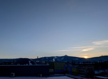 Momentka 20. 2. 2026 z terasy iQLandie s právě mizícím Sluncem a slabým srpkem Měsíce nahoře.