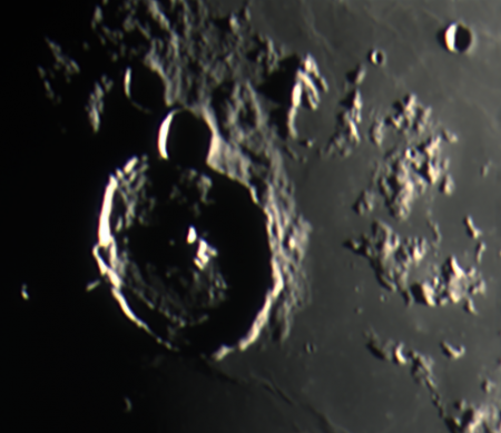 Kráter Gassendi ukázal zajímavé detaily - všimněte si dvou tmavých proužků ve valu kráteru a světlého tenkého výběžku směrem do temné strany Měsíce.
