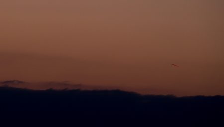 Měsíc ve 21:04:40 SELČ lze slabě vidět vlevo od letícího letadla. Snímek v podání podobném pohledu okem do triedru.