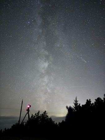 Mléčná dráha s kometou, foťákem a pozorovatelem v popředí. iPhone 15 - 26mm, f/1,6, 6400 ISO, 30s, autor: Jakub Kuřák